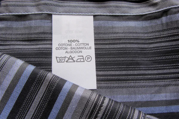 Washing instructions on cotton vertical stripes shirt — Stock Photo, Image