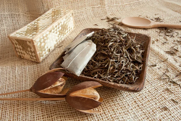 Hojas de té secas en una taza de madera, estilo país — Foto de Stock
