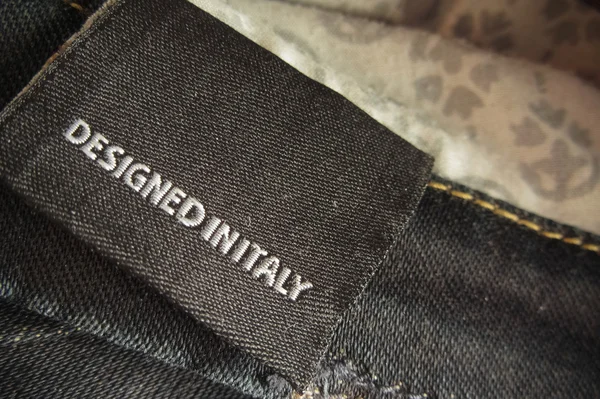 Designed in Italy label on blue jeans — Stock Photo, Image