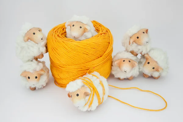 Niedliche Schafe spielen zusammen mit einem Knäuel aus gelber Wolle — Stockfoto