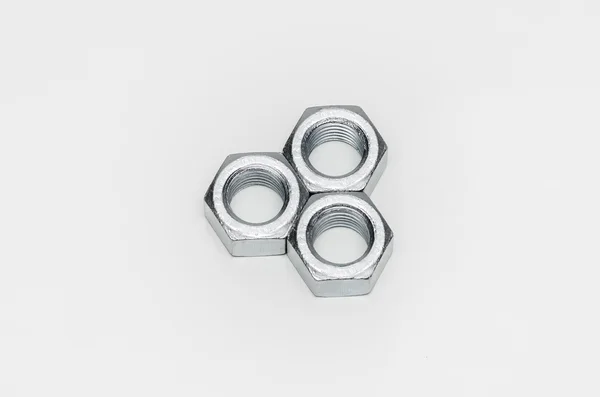 Beyaz arka plan üzerinde metal fındık düzenlenmiş