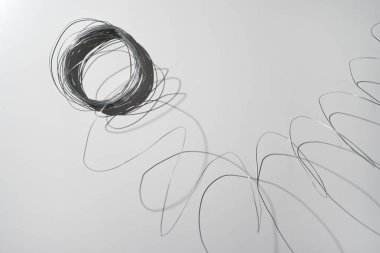 Beyaz arka planda gümüş kablolar. Kablonun ucunu çekince, spiral ortasındaki merceğe yaklaşıyor. sert ışık. modern minimalizm.