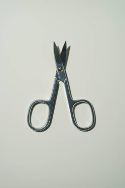 Koyu gri metal, açık tırnak makası çerçevenin ortasındaki bej ışıklı arka planda yatar. Model yap. en üstteki görünüm