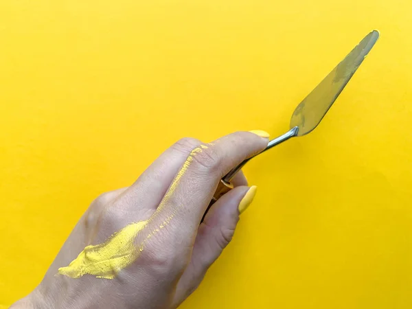 Sarı boyayla boyanmış bir el. Çene..