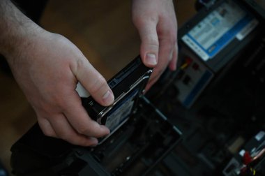 Bilgisayar teknisyeni sabit diski masaüstü bilgisayar çantasına yüklüyor.