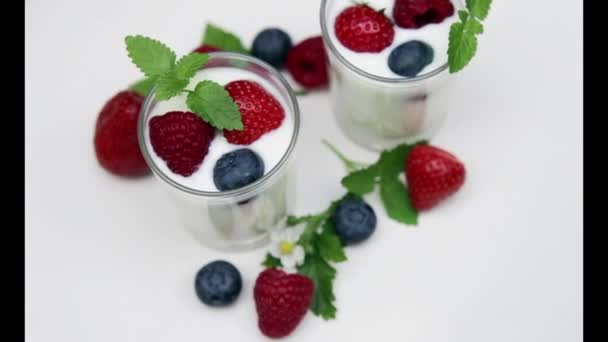 Yogurt naturale con bacche fresche che ruotano isolate su withe e luce del giorno — Video Stock