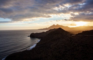 Cabo de Gata Ulusal Parkı Almeria Endülüs 'te altın gün batımında siluet kıyıları
