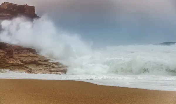 Fale sztorm przewrócić plaży i klaskać na skałach — Zdjęcie stockowe