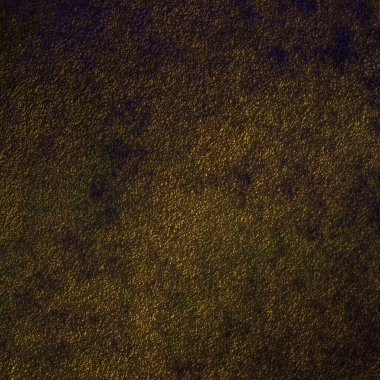 Grunge kahverengi altın arka plan, koyu kenarlı beton taş desen duvar ve merkezde spot ışığı.