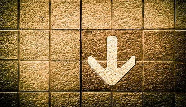 Close up Arrow sign on floor at the sky train station, bangkok, Thailand. black and gold color process — Stock Photo, Image