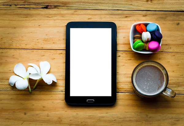 Siyah tablet ve sıcak kahve renkli tatlı ve beyaz çiçek sıcak sesi ahşap tablo.