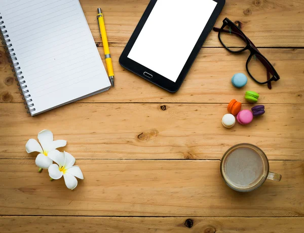 Tableta negra y libro vacío con café caliente y dulce colorido en la mesa de madera en tono cálido. espacio de copia — Foto de Stock