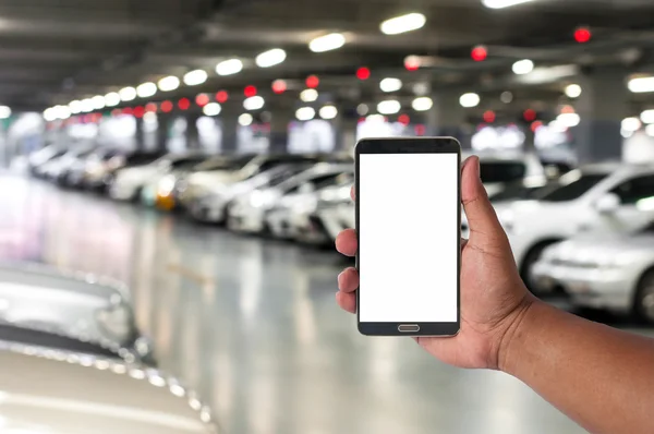 Adamın elini bokeh ışık arka plan ile otopark araba bulanık cep telefonu idare