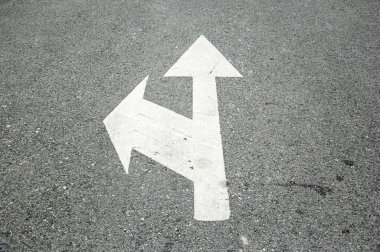 Beyaz iki yönlü ok sembol siyah asfalt yol yüzeyinde