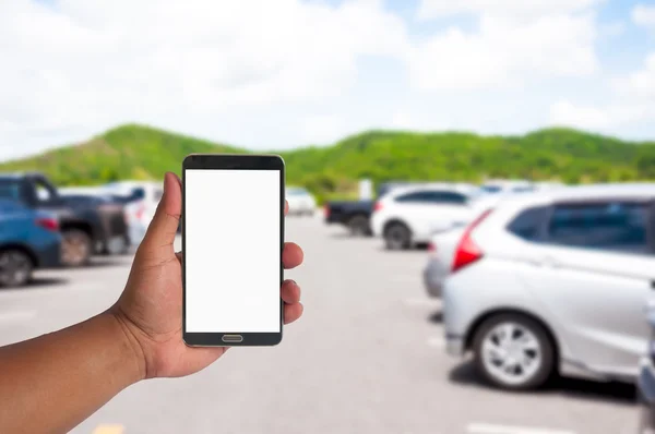 Adamın elini bokeh ışık arka plan ile otopark araba bulanık cep telefonu idare