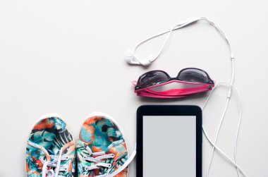 renkli Tuval Ayakkabı, güneş gözlüklü beyaz kulaklık ve beyaz zemin üzerine Tablet. seyahat için aksesuarlar