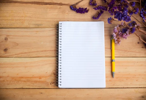Öppen tom anteckningsbok och gul penna med torkad blomma på trä bakgrund, varm ton — Stockfoto