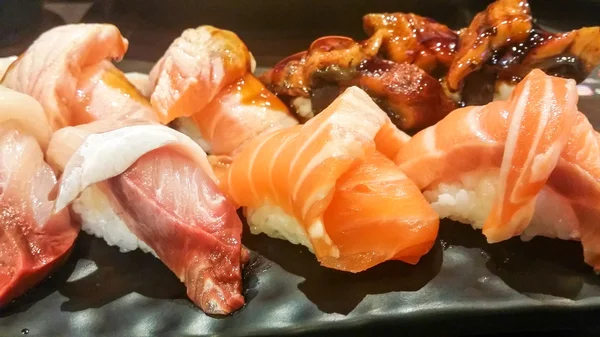 黒のプレートにさまざまな寿司 — ストック写真