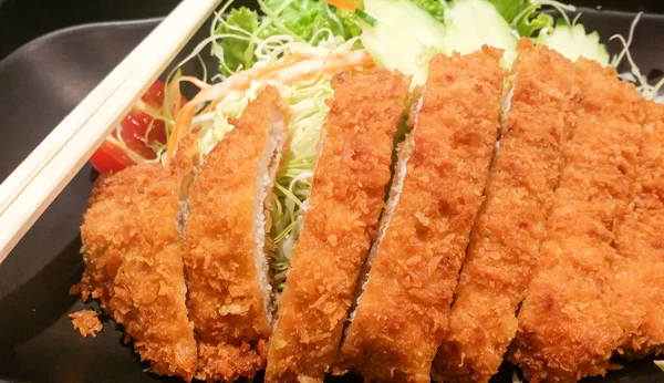 Carne di maiale fritta croccante con verdure in piatto nero, tonkatsu, cibo giapponese — Foto Stock