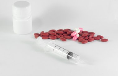 Beyaz plastik şişe zekâ dökülmesini koyu kırmızı ve pembe hap