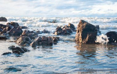 Deniz köpüğü içinde boş bir kayalık sahil Tayland ile dramatik gökyüzü ve ışık önce fırtına ve yağmur