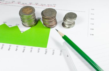 kalem ile yeşil grafikler ve arka plan üzerinde paralar. para ve mali kavramı.