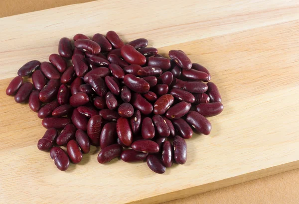 木材の背景に赤い豆の種 — ストック写真