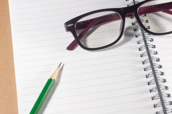Öppen tom anteckningsbok med grön penna, glasögon och fodrad sida — Stockfoto