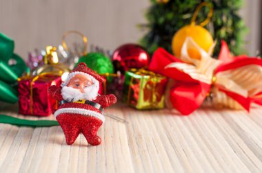 Noel baba bebek hediye kutusu üzerinde tahta arka plan ile bir Noel ağacı karşı