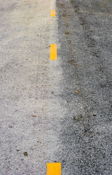Жовта штрихова лінія на старій асфальтовій дорозі — стокове фото