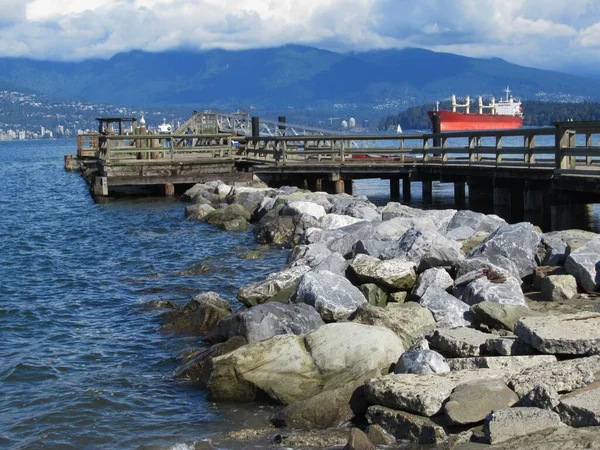 Vancouver 'daki Jericho Sahili' nde kayalıklı ve ahşap iskeleli güzel deniz doğası manzarası