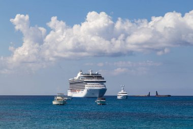 Büyük lüks bir yolcu gemisi, Karayipler 'de, mavi gökyüzü ve arka planda beyaz bulutlar.