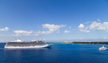 Büyük lüks bir yolcu gemisi, Karayipler 'de, mavi gökyüzü ve arka planda beyaz bulutlar.