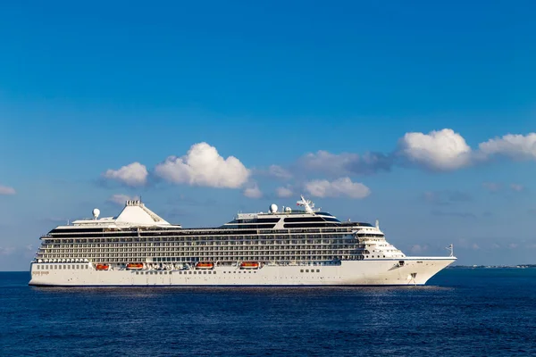 Büyük lüks bir yolcu gemisi, Karayipler 'de, mavi gökyüzü ve arka planda beyaz bulutlar.