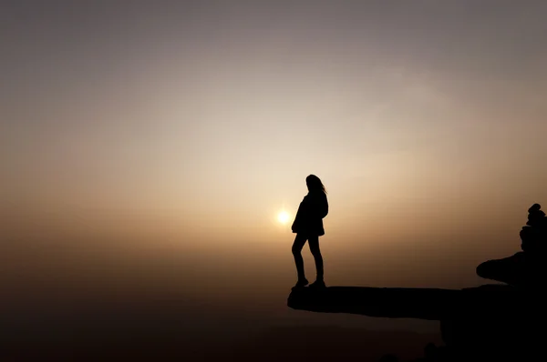 Силует успіху жінки на вершині гори на заході сонця, вибірковий — стокове фото