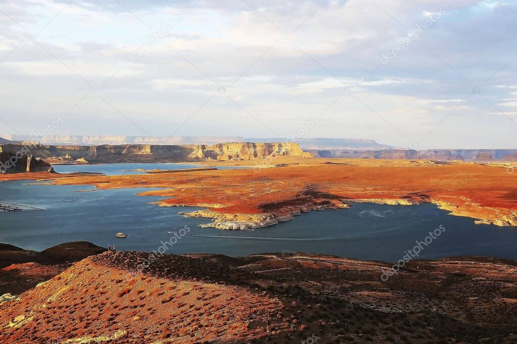 Lake Powell is large and stretches across two states, and therefore there are two ports here: North Bullfrog Marina and South Wahweap Marina. the rugged coastline, blue water against the background of a red rocky shore, the lake looks very attractive