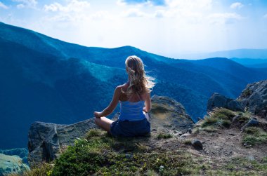 Genç sarışın kadın güzel dağ manzarası içinde meditasyon