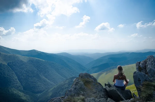 Молодая блондинка медитирует на прекрасном горном ландшафте — стоковое фото