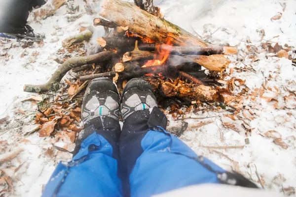 Détente au coin du feu de camp en hiver - femme en bottes de randonnée — Photo