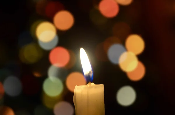 Luce di candela accesa su bacground colore astratto. Bokeh colorato — Foto Stock