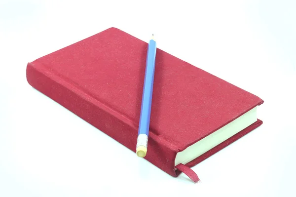 Notebook and brown feather on wooden table. — Stock Photo, Image