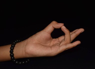 Prithvi Mudra 'daki eller siyah arkaplanda izole edildi.