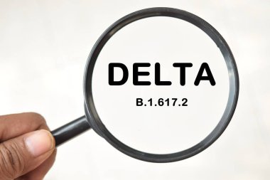 Yeni covid-19 delta varyant sembolü. Adam elinde bir büyüteç tutuyor..