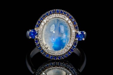 Çok değerli taşları olan altın bir yüzük ay taşı, safir, yakın plan siyah elmaslar.