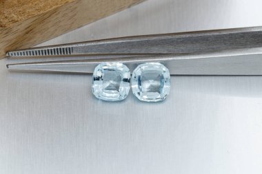 Gri arka planda cımbızla, makro mineral katmanlı taş akuamarin