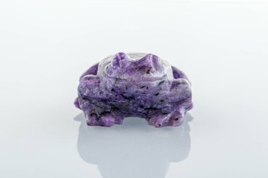 Beyaz arka planda Charoite 'li bir kurbağanın güzel biblosu.