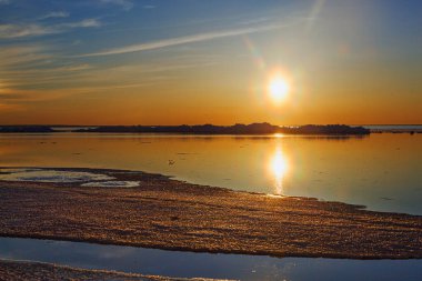 Deniz kenarında güzel bir kış günbatımı. Buzdağı da yakında.