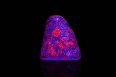 macro mineral stone ruby under ultraviolet light on a black background close-up clipart