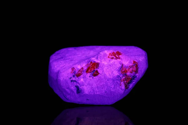 黒の背景に紫外線の下にあるマクロ鉱物の石のスピネル — ストック写真