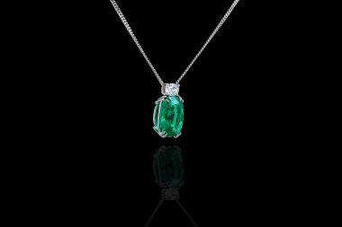 Zümrüt ve siyah arka planda zinciri olan güzel bir kolye.